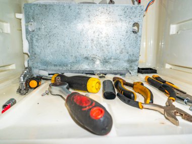 Buzdolabının dondurucusunda çalışan bir alet. Buzdolabı tamiri için ana araç. Soğutma ekipmanı bakım teknisyeni. Tornavida ve pense. İngiliz anahtarı. Ev aletleri tamirhanesi..