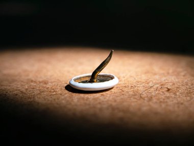 Ahşap masa makro fotoğrafına eğilmiş raptiye. Kırtasiye malzemeleri. Arkaplan resmi. Mesaj için yer. Keskin. Yakın çekim..