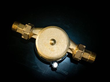 Fındıklar için su sayacı. Siyah arka plan. Tesisat malzemeleri. Tesisat tamiri. Tesisat tamircisi. Boru hattı. Arkaplan resmi. Metnin için yer.