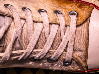 Beyaz bağcıklı eski bir spor ayakkabıyı bağlamak.