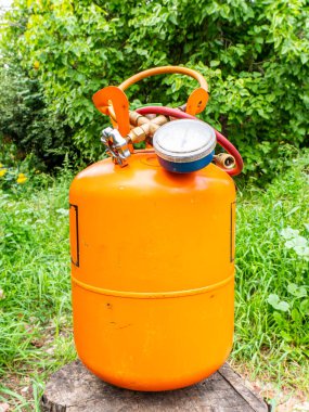 Soğutucu silindir ve basınç göstergeli hortumlar. Freonlu turuncu şişe. Buzdolabı ve klimaların tamiri için basınç göstergesi. Buzdolabı ve klima onarım aracı.