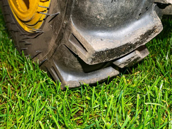 农业拖拉机轮子在绿草草坪上 车胎合适 车辆轮胎橡胶胎面 用拖拉机把城市公园的绿色草坪推倒 把你的文字放好 — 图库照片