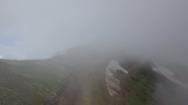 Дорога в облаках высоко в горах — стоковое видео