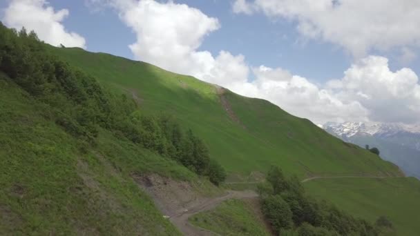 Vlucht boven de weg onder de groene heuvel van de berg — Stockvideo