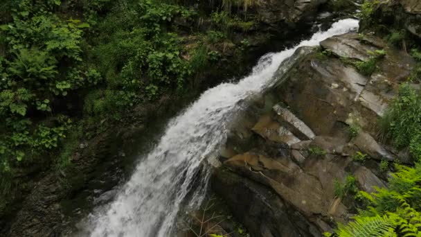 Falling water, rocks and green vegetation