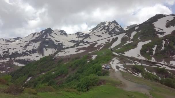 在山谷空中射击的山的雪的顶部和二个小房子 — 图库视频影像