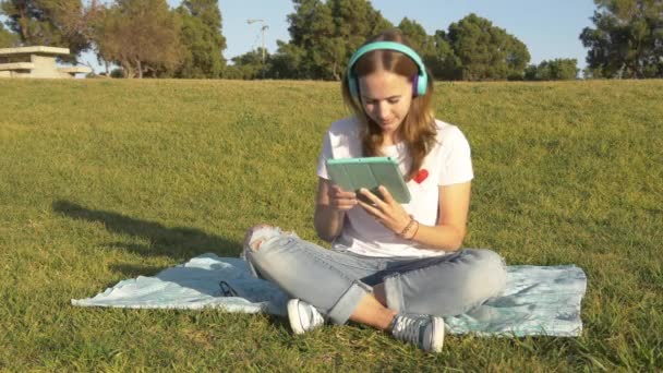 Trabalho adolescente com tablet no parque — Vídeo de Stock
