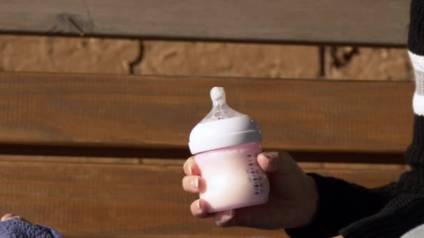 闭手检查婴儿配方奶粉的温度 — 图库视频影像
