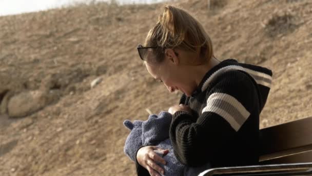 Madre sonriendo y hablando con el pequeño bebé al aire libre — Vídeos de Stock