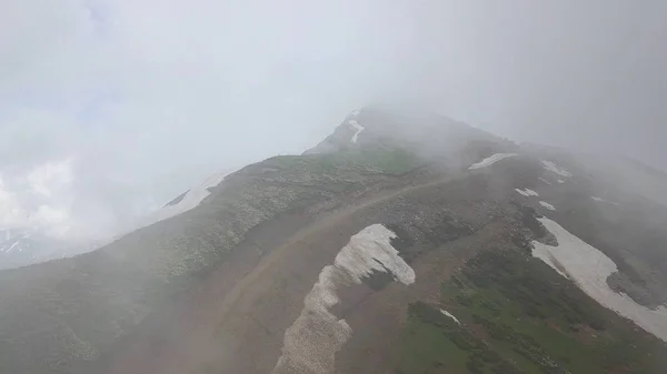 Pico coluna de pedra em nuvens, voando sobre no dia de verão — Fotografia de Stock