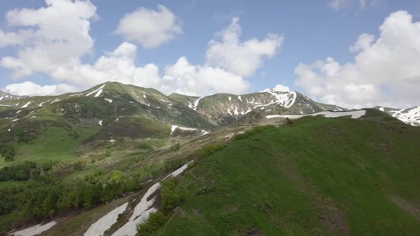 Воздушная съемка вершин зеленых гор с небольшими снежными пятнами — стоковое фото