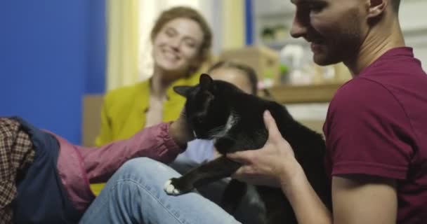 Lycklig familj leker med katt hemma. — Stockvideo