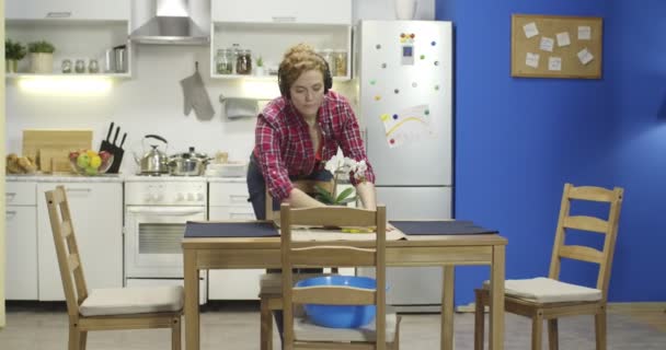 Jonge vrouw die stof afveegt en haar keuken schoonmaakt. — Stockvideo