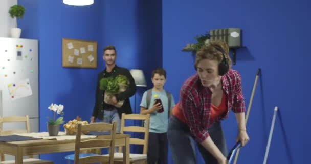 Hausfrau tanzt, singt und betritt mit Mann und Sohn die Küche. — Stockvideo