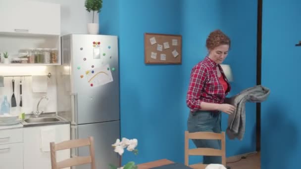 Kvinnan lägger saker från stolen. — Stockvideo