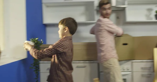 Familia feliz desempacando cajas en la cocina . — Foto de Stock