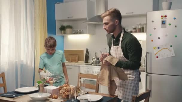 Jongen helpt zijn vader en zet appels. — Stockvideo