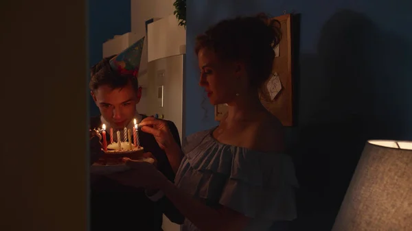 Menschen stehen mit einer Torte im Dunkeln. — Stockfoto