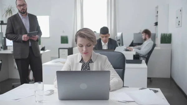 Colegios de mujeres y hombres se sientan en una mesa y trabajan . — Foto de Stock