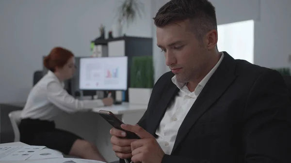 Mulher escrever algo no papel e tipo de homem no telefone no trabalho . — Fotografia de Stock