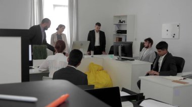 İnsanlar ofiste oturup, şef onlarla konuşur..