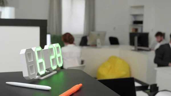 Horloge est sur l'étagère et derrière eux employés de bureau . — Photo