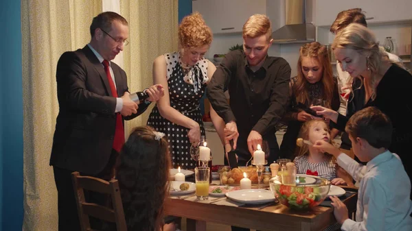 Group of people have a dinner, put food on plates.