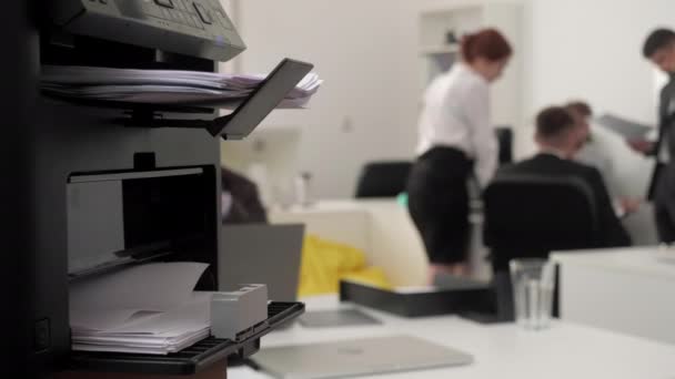 Focus sur l'imprimante, sur le backgroud il y a des gens . — Video