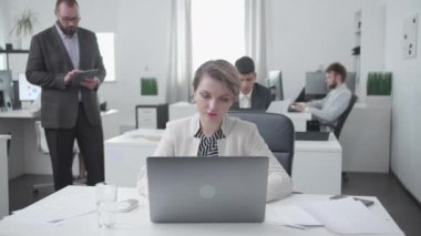 Kadınlar ve erkekler collegues bir masada oturup iş.