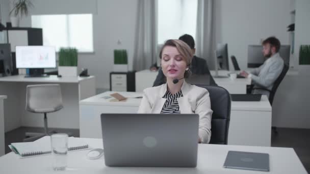 Vrouw en haar collega's zitten aan een tafel en werken. — Stockvideo