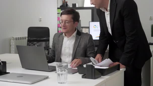 Två man på kontoret diskuterar dokument. — Stockvideo