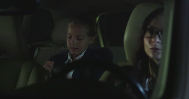 Γυναίκα και μικρό κορίτσι οδήγηση στο αυτοκίνητο τη νύχτα. — Αρχείο Βίντεο