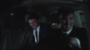 İki adam araba sürer ve konuşur..