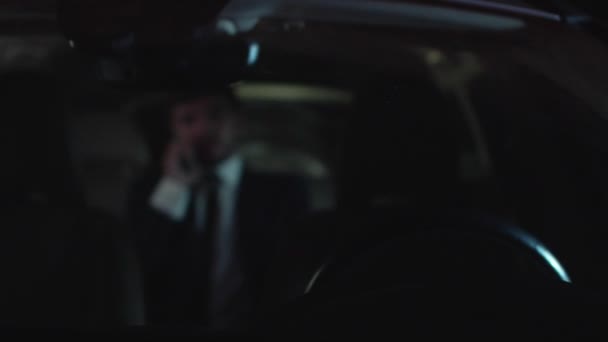 Ο άνθρωπος μιλάει στο τηλέφωνο με αυτό το αυτοκίνητο το βράδυ. — Αρχείο Βίντεο