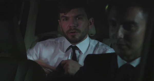 El hombre conduce en la parte trasera de un coche por la noche . —  Fotos de Stock