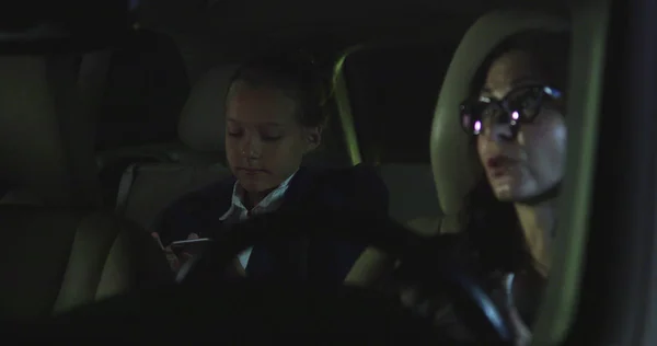 Mujer y niña conducen en coche por la noche . —  Fotos de Stock