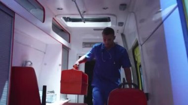 Sıhhiyeci ambulans vagonundan tıbbi çantayla insin.