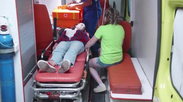 Injured woman lie on strecher in ambulcanse car. — Stock Video