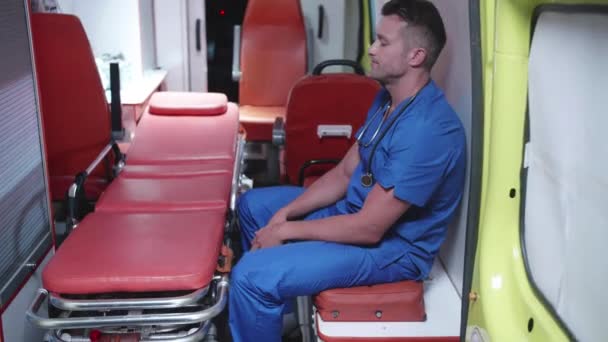 Unhappy corpsman sit in ambulance car. — Stock Video