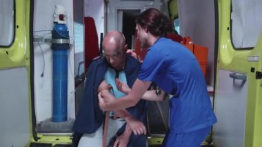 Oksijen maskeli adam hemşire ile gece ambulans arabada oturup.