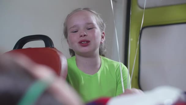 Kleines Mädchen sitzt im Krankenwagen um Mutter. — Stockvideo