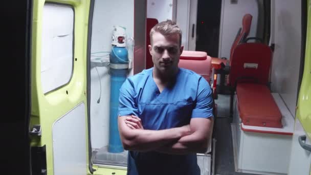 Forense feliz de pie en el fondo del coche ambulancia . — Vídeos de Stock