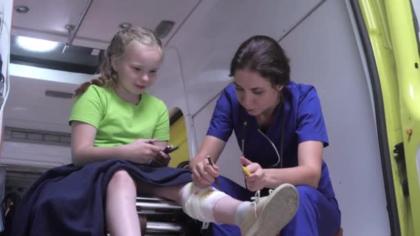 Sick girl sit with nurse in ambulance car. — Stock Video