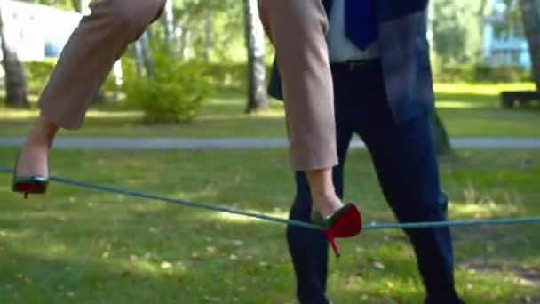 Kvinna i klackar går på ett rep på gården. — Stockvideo