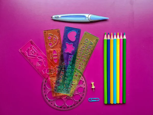 Various school material in composition on purple background
