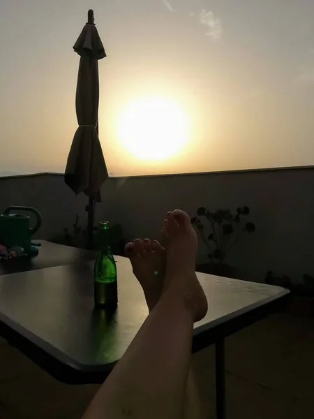 Enjoying a beer with feet on a terrace table