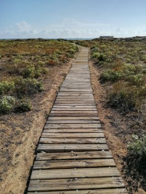 Akdeniz'de arka plan ile plaj erişmek için ahşap geçit