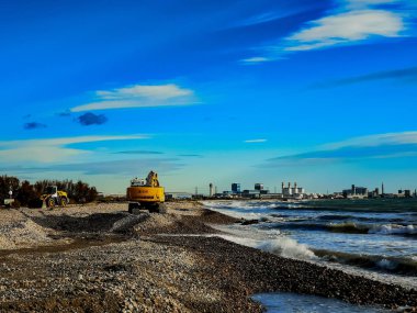 Bir kumsalda çalışma Ekskavatör