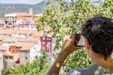 Bir kasabanın fotoğrafını çeken genç adam