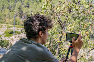 Bir kasabanın fotoğrafını çeken genç adam
